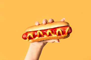 Sticker - Woman holding tasty hot dog on yellow background