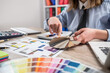© RomanR - female designer work with house blueprint and color palette samples