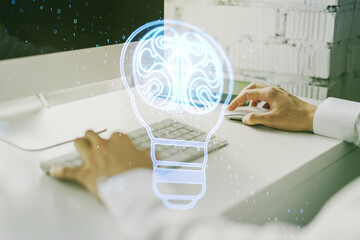 Aufkleber - Creative light bulb with human brain hologram and with hands typing on computer keyboard on background, artificial Intelligence and neural networks concept. Multiexposure