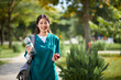 © DragonImages - Portrait of cheerful medical nurse spending lunch time in park, having fresh apple and water
