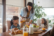 © Halfpoint - Mother prepares breakfast for children, in the morning. Maternal love and care for household and family.