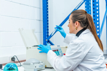 Wall Mural - female biologist extracting blood samples from a centrifuge machine