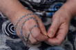 Różaniec owinięty wokół dłoni modlącej się kobiety 