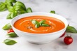 © Maximilien - Simplicity in a Bowl: Tomato Soup Served on a White Table, Garnished with Fresh Basil Leaves for a Burst of Flavor and Freshness