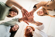 © Studio Marmellata - From below of cheerful young women smiling and showing palms while looking at camera against blurred background in modern office