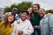 Multiracial group of friends outdoors smiling and having fun. International students happy together looking at camera. Portrait of young people from generation Z . Intercultural relations, community.