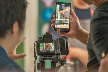 back screen video recording by videographer record video clip by camera and smartphone to online social internet live. vlogger watching recording clip streaming online a man make a cup of coffee drip