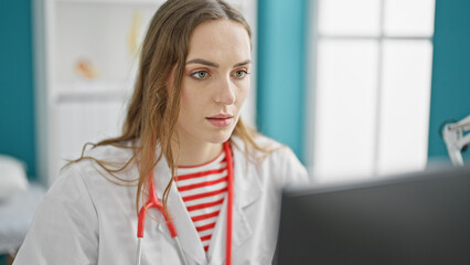 Young blonde woman doctor using computer working at clinic