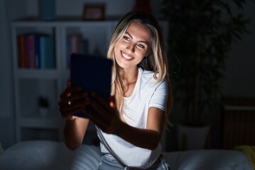 Poster - Young blonde woman using touchpad sitting on bed at bedroom