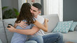 © Krakenimages.com - Smiling beautiful couple enjoying a winning video game at home, hugging each other in celebration indoors on their comfortable sofa