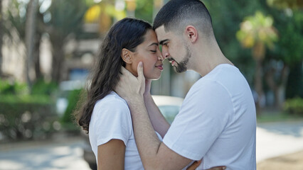 Wall Mural - Beautiful, confident couple, smiling and hugging, deeply looking into each other's eyes expressing positive joy, basking in sunlight at the city park. lifestyle of love and happiness outdoors.