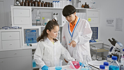 Wall Mural - Two serious-faced scientist partners standing together, speaking about medical research analysis in lab