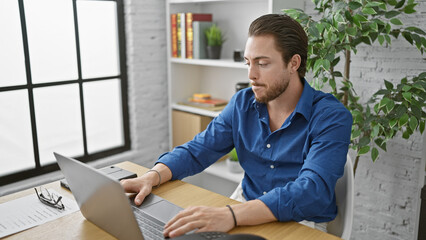 Wall Mural - Young hispanic man business worker using laptop working at the office