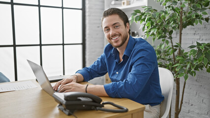 Wall Mural - Young hispanic man business worker using laptop working at the office