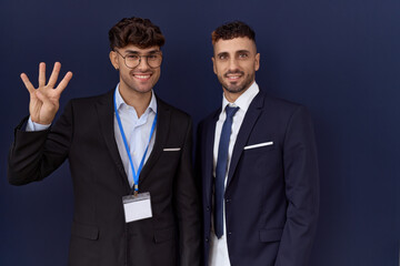 Canvas Print - Two hispanic business men wearing business clothes showing and pointing up with fingers number four while smiling confident and happy.