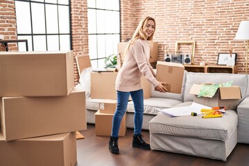 Wall Mural - Young woman smiling confident holding package at new home