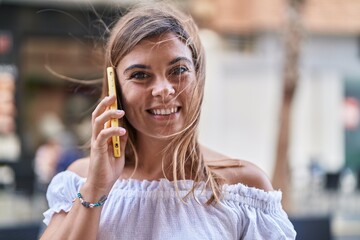 Canvas Print - Young woman smiling confident talking on the smartphone at street