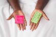 © Krakenimages.com - African american woman holding condom and birth control pills at bedroom