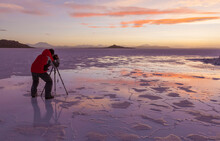 View Of A Person Taking Photos At Uyuni Salt Flat At Sunset, Salar De Uyuni, Bolivia.