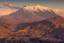 View Of La Paz Downtown At Sunset With Mount Illimani In Background, Bolivia.