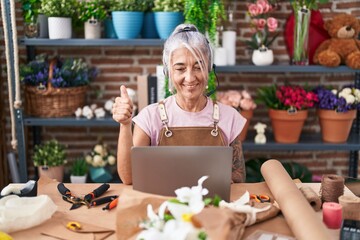 Sticker - Middle age woman with tattoos working at florist shop doing video call smiling happy and positive, thumb up doing excellent and approval sign