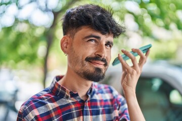 Poster - Young hispanic man smiling confident listening audio message by the smartphone at street