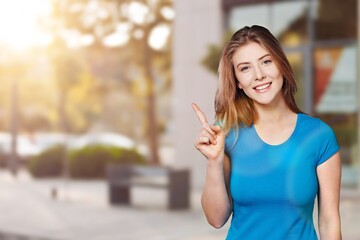 Poster - Young beauty woman pointing to background.