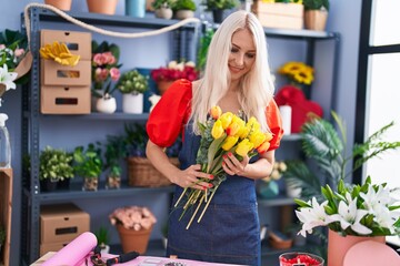 Sticker - Young blonde woman florist holding bouquet of flowers at florist store