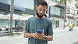 © Krakenimages.com - Young hispanic man using smartphone and earphones at street