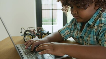 A black child learning to program arduino car, education and study concept.