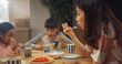 © Kitreel - Happy Korean Family Members Enjoying Delicious Food Together. Young Parents and Their Two Children Eating Traditional Dishes at Home While Sitting at Their Kitchen Table