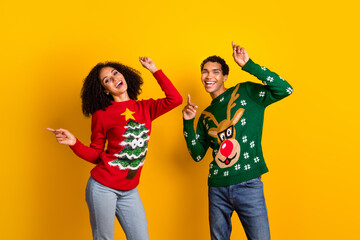 Sticker - Photo of excited carefree guy girl dressed christmas ugly print pullovers dancing having fun isolated yellow color background