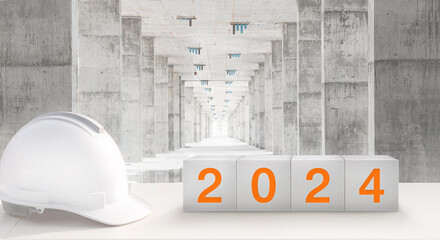 Wall Mural - Happy New Year 2024 Real Estate and Construction Industry. White Helmet and a numbered concrete cube on the desk of an engineer or construction worker.