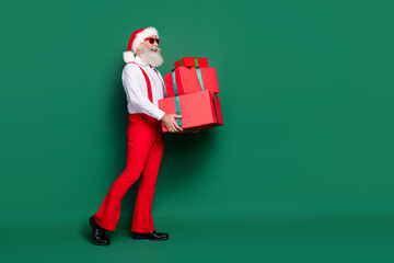 Poster - Full length photo of positive dreamy guy wear x-mas costume delivering presents pile empty space isolated green color background