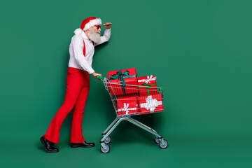 Sticker - Full length photo of sweet curious guy wear x-mas costume walking tray looking far away empty space isolated green color background