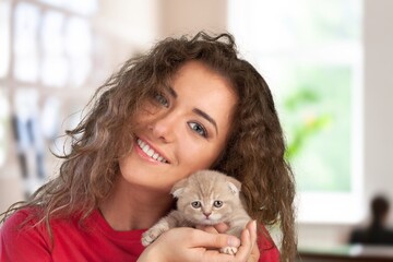 Canvas Print - Millennial young cheerful female cuddling cute domestic kitten