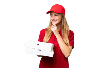 Wall Mural - Young caucasian pizza delivery woman with work uniform picking up pizza boxes over isolated background looking to the side and smiling