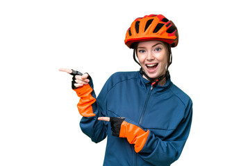 Wall Mural - Young cyclist woman over isolated chroma key background surprised and pointing side