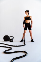 Poster - Young female athlete training in a gym using sport equipment. Fit woman working out . Concept about fitness, wellness and sport preparation.