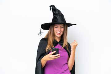 Wall Mural - Young caucasian woman costume as witch isolated on white background with phone in victory position