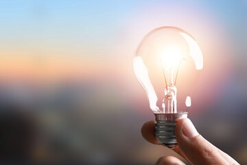 Wall Mural - hand holding classic light bulb for renewable energy.