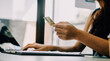 © ARMMY PICCA - Close up woman hand using credit card and smartphone laptop for buying online shopping