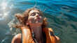Serenity in water: Woman floating calmly in blue sea with life jacket.
