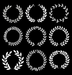 a set of vintage white laurel leaf wreaths on black background