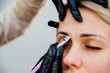 The makeup artist performs long-term eyebrow styling and paints the eyebrows. Lamination of eyebrows. Professional makeup and facial care. Makes markings for permanent makeup.