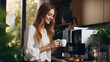 © Nataliya - Woman using coffee machine to make big mug of coffee at home. Woman wearing silk robe at home while preparing a latte