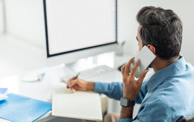 Aufkleber - Businessman multitasking with phone and notes, looking at blank monitor