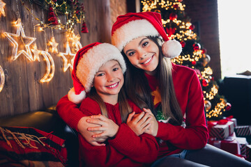 Poster - Photo of pretty charming small sisters wear red ugly print new year sweaters cuddling hugging indoors apartment room