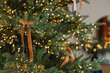 © RooM The Agency - Close-up of an illuminated Christmas tree with ribbon tied bow decorations in a living room