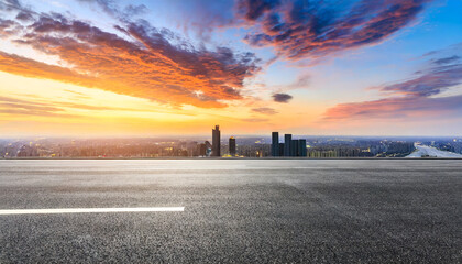 Wall Mural - asphalt road and city skyline with colorful sky clouds at sunset